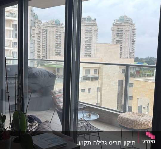 מרפסת עם חלונות זכוכית ונוף לבניינים